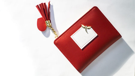 Red leather wallet with a gift tag on a white background, top view