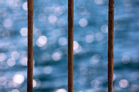 The blue sea behind the rusty barsの写真素材
