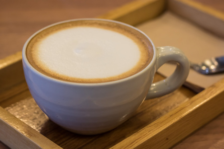 Cappuccino coffee in white cup on wooden table.の写真素材