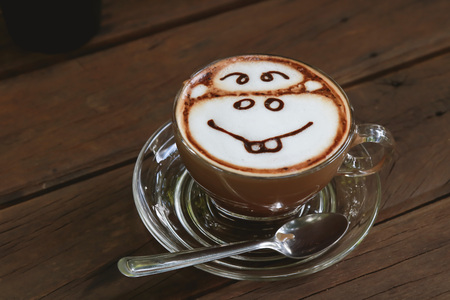 Coffee cup on the wooden table, Mocca hot coffee, Monkey frothy foamの写真素材