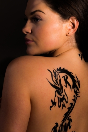 Beautiful female with tribal dragon tattoos の写真素材
