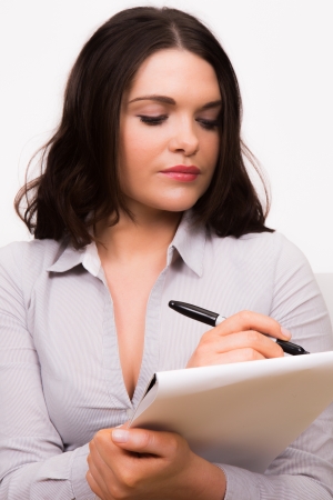 Young professional female writing on padの写真素材