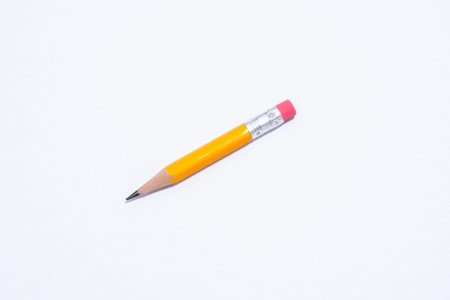 A short yellow pencil isolated on a white background. The pencil has an eraser on the end. Copy Space.の写真素材