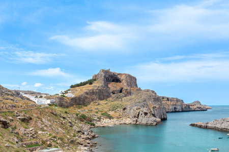 The ancient theatre of Lindos on the island of Rhodes. St Paul's bay sits in the foreground with the sea in the backgroundの写真素材