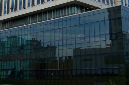 Sky and clouds reflected in building windowsの写真素材