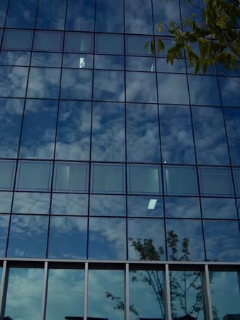 Sky and clouds reflected in building windowsの写真素材