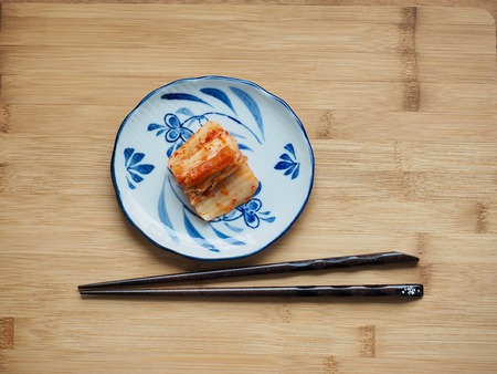 A Korean food, kimchi in a plate on a wooden tableの写真素材