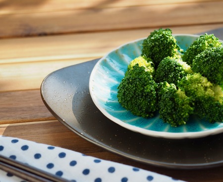 Boiled broccoli and chopsticks in waterの写真素材