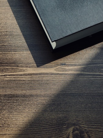 Wooden board and black bookの写真素材