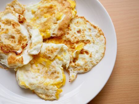 Fried eggs in a white porcelain dishの写真素材