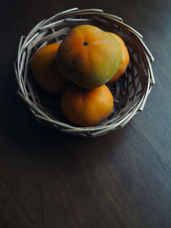 Fresh organic fruit persimmons in basketの写真素材