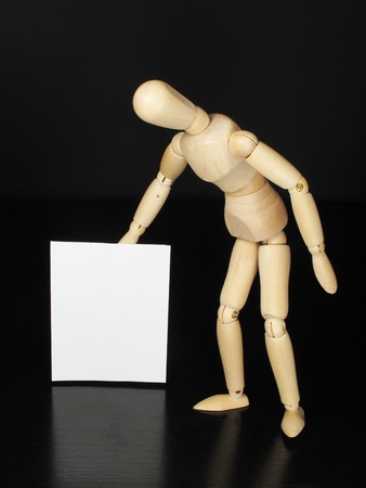 a humanoid doll with black background and white sign to write thingsの写真素材