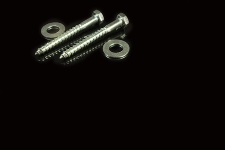 two screws and washers on a black backgroundの写真素材