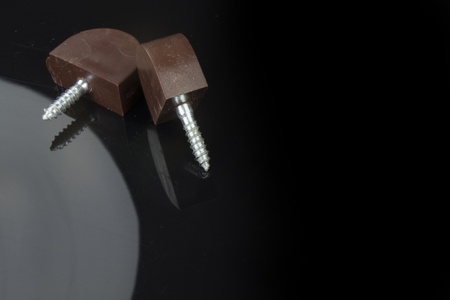 the two pieces of hardware with a screw and its reflectionの写真素材