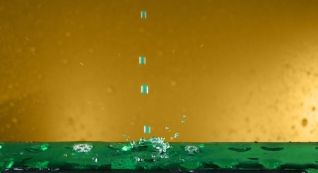 drops of water splashing on yellow and greenの写真素材