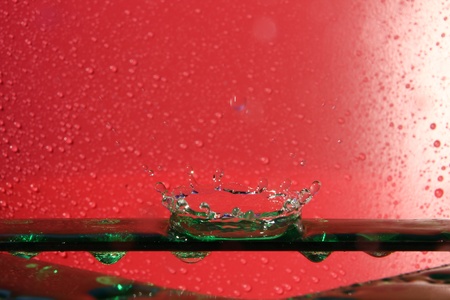splashing water droplets on red backgroundの写真素材