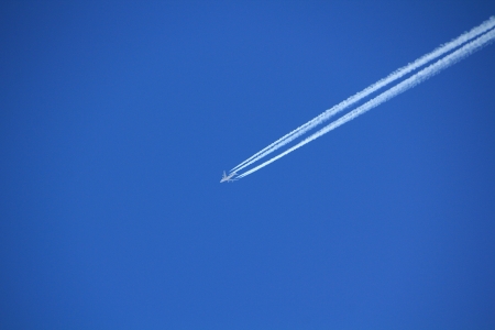 airliner flying high and leaving trailの写真素材