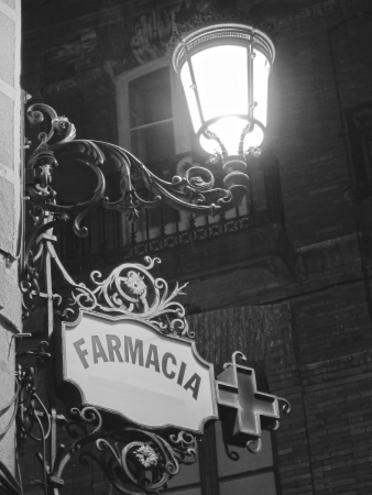 in spanish ,pharmacy old poster under a streetlight at duskのeditorial素材