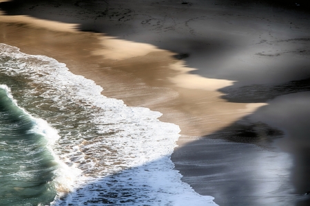 waves breaking on the shore of a beach at sunsetの写真素材