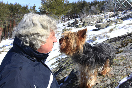 mature man's hair looks with love for his dog in the snowのeditorial素材