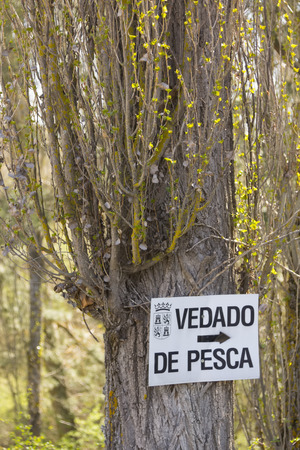 sign on a tree laying on Spanish WARREN FISHINGのeditorial素材