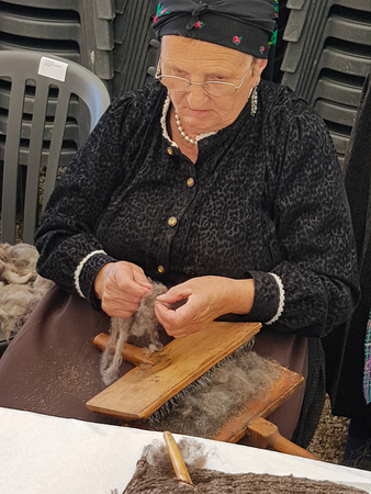 Ainsa 10 September 2017: Spinner with traditional Pyrenees costume cardinating traditional wool in Ainsa Spain.のeditorial素材