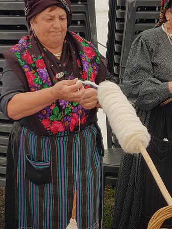 Ainsa 10 September 2017: Spinner with traditional Pyrenees costume cardinating traditional wool in Ainsa Spain.のeditorial素材