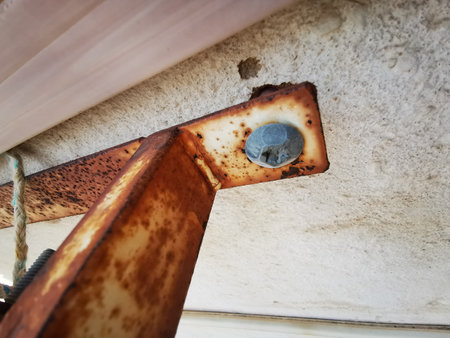 rusty iron bracket screwed with an old screwの写真素材