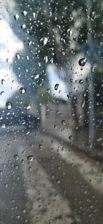 Raindrops on a car window, creating a visual effect of blurring and reflectionsの写真素材