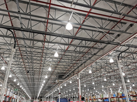 Large warehouse illuminated with numerous lights and a multitude of spotlights on the ceilingの写真素材