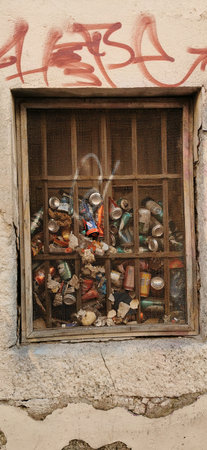 Urban Decay: Graffiti and Trash Behind a Rusty Windowの写真素材