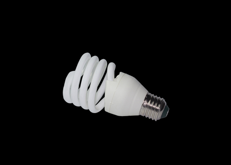 Energy-saving fluorescent electric light bulb on a black background.の写真素材
