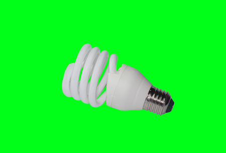 Energy-saving fluorescent electric light bulb on a green background.の写真素材