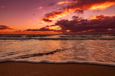 A beach view beautiful sunset overlooking the dramatic clouds and sea from ground levelの写真素材