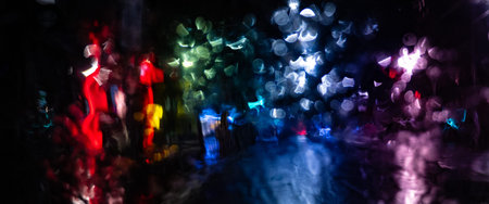 Blurry city lights at night distorted through a rainy windscreenの写真素材