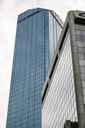 Glass skyscraper towers reflecting the overcast skyの写真素材