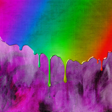 Bright rainbow colored paint dripping over purple canvas textured pattern background designの写真素材