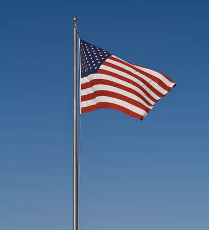 The Stars and Stripes set against a perfectly blue skyの写真素材