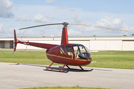 A generic helicopter parked outside its hangar at an airport のeditorial素材