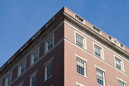 Brick built apartments in Boston with sash windows against a blue sky.