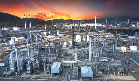 Panoramic view of the oil and gas refinery industry, with mountains in the background at duskの写真素材