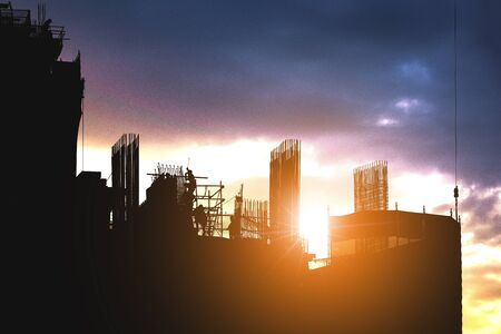 The silhouette of a worker working at a construction site, building construction industryの写真素材