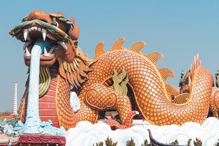 Chinese-style dragon statue releasing water from the mouth on the clouds, Suphan Buri Province, Thailandの写真素材