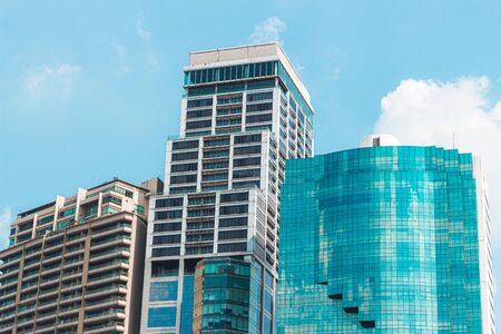 3 Tall Buildings with buildings in the middle higher than the blue skyの写真素材