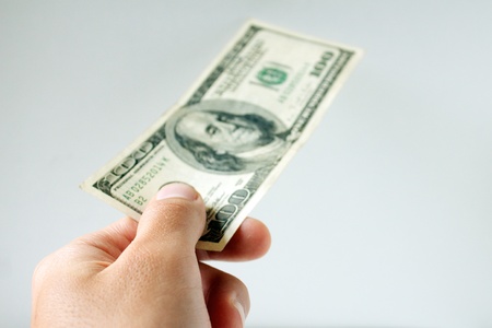 Hand giving one hundred US  dollarsの写真素材