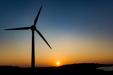 A turbine used to generate power is silhouetted by the sunset in Saltash, Cornwallの写真素材
