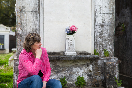 Woman in historic New Orleans cemetery   Copy space on crypt if needed の写真素材