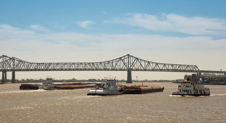 Commercial shipping on Mississippi River at New Orleans.  Barge and tug traffic beneath bridge.  Copy space at top.の写真素材