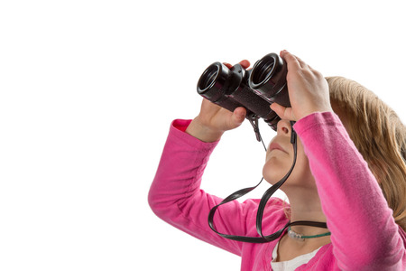 Young girl with binoculars looking up at copy space.  Isolated on white background.の写真素材