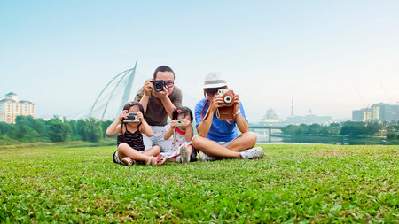 Happy mother, father and daughter in the parkの写真素材